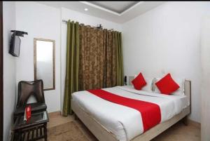 a bedroom with a large bed with red pillows at Hotel Bir Stay- Near Nizamuddin Dargah in New Delhi