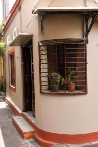 a building with a window with potted plants on it at Jagdamba Bhawan in Kolkata +1 photo