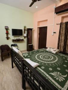 a bedroom with a bed with a green bedspread at Jagdamba Bhawan in Kolkata