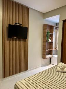 a bedroom with a tv on the wall and a bed at Pousada Mares Maragogi in Maragogi