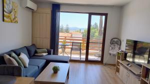 a living room with a blue couch and a balcony at Апартамент Славяна in Velingrad