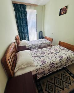 two twin beds in a room with a window at Apartment near Tskaltubo spa resort in Tsqaltubo