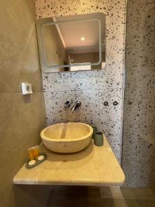 a bathroom with a bowl sink and a mirror at Stella Studios in Patitiri