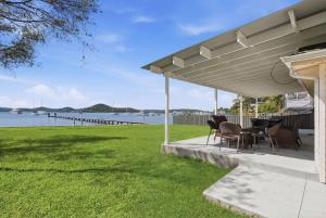 a patio with a table and chairs under a pavilion at Central Coast Waterfront 2BR with Jetty Access in Koolewong