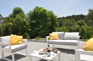 a patio with two chairs and a couch and a table at Vale De Água Equestrian Resort in Odemira