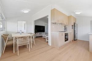 a kitchen and living room with a table and a dining room at Central Coast Waterfront 2BR with Jetty Access in Koolewong