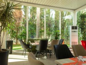 a restaurant with tables and chairs and windows at Ibis Rabat Agdal in Rabat