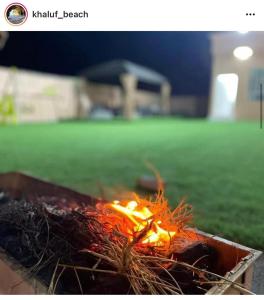 a fire in a box in front of a field at شاليه شاطئ خلوف in Khalūf