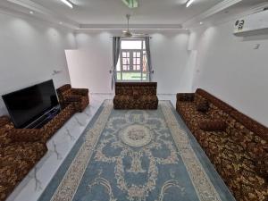 a living room with couches and a flat screen tv at شاليه شاطئ خلوف in Khalūf +1 photo