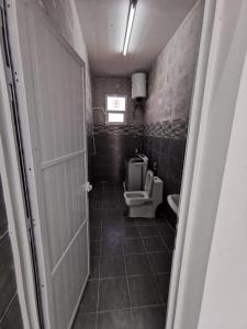 a small bathroom with a toilet and a window at شاليه شاطئ خلوف in Khalūf