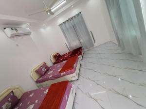 a room with two beds in a room with marble floors at شاليه شاطئ خلوف in Khalūf