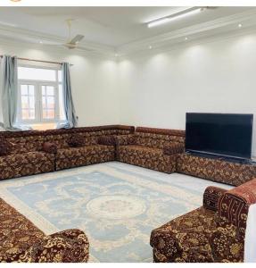 a living room with a couch and a flat screen tv at شاليه شاطئ خلوف in Khalūf