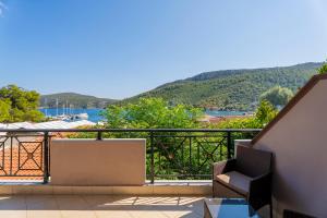 a balcony with a view of the water and mountains at Studios Diogenis in Porto Koufo