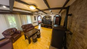 a living room with leather chairs and a tv at Gorska Vila Sisevac in Sisevac