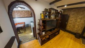 a living room with a flat screen tv and a entertainment center at Gorska Vila Sisevac in Sisevac