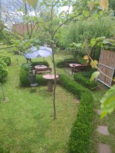 a garden with benches and a table with an umbrella at Dukii in Vrnjci