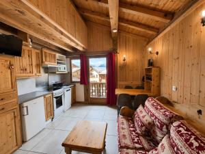 a kitchen with a couch and a table in a room at Le Tyrol in La Plagne Tarentaise