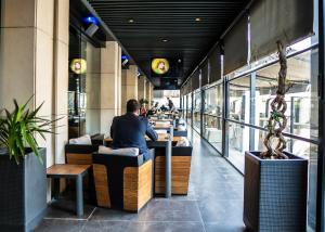 a man sitting at a counter in a restaurant at The V Hotel in Baghdād +14 photos