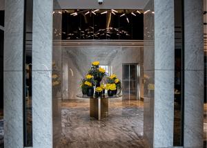 a lobby with a table with yellow flowers on it at The V Hotel in Baghdād