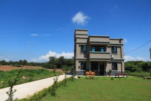 a house sitting on top of a grass field at Ancient Official Road Homestay in Jinhu