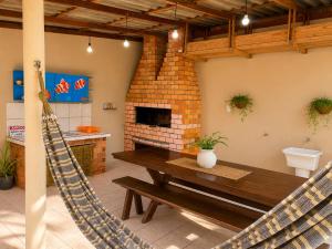 a living room with a wooden table and a hammock at GH Pinheira in Palhoça