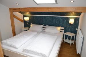 a bedroom with a large white bed with two pillows at Ferienwohnung Auszeit | Chiemgau Karte in Grassau