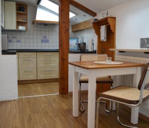 a kitchen with a table and chairs in a kitchen at Ferienwohnung Auszeit | Chiemgau Karte in Grassau