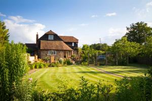 a house with a large lawn in front of it at Magpies Lodge in Slinfold