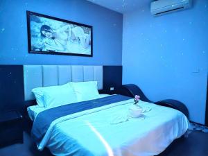 a blue room with a bed with a tv on the wall at Pickle Hotel Từ Sơn in Ðại Sơn