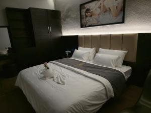 a bedroom with a large white bed with a vase on it at Pickle Hotel Từ Sơn in Ðại Sơn