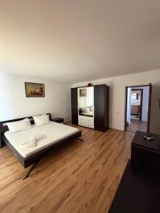 a bedroom with a bed and a wooden floor at Casa Doros in Eforie Sud