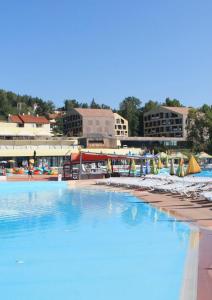 a large swimming pool with chairs and umbrellas at Apartment Petra Zabok Horizon Suite in Zabok