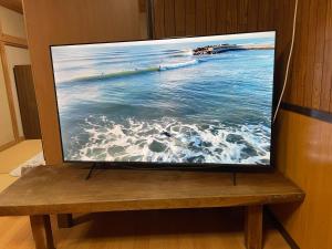 a flat screen tv sitting on top of a wooden bench at Iioka-classic in Asahi