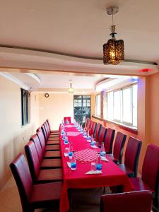 a long table with red tables and red chairs at Novo Axora Lounge & Accommodation Kimbo Ruiru Kimbo Lopha Stage in Ruiru
