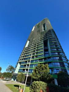 a tall building with a blue sky in the background at Floor-to-Ceiling Park View Oasis at Olympic Park Free Parking Sleeps 5 in Sydney
