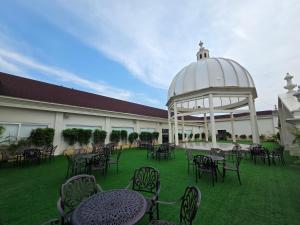 an outdoor patio with tables and chairs and a gazebo at Rajwada Hotel and Resort in Bareilly