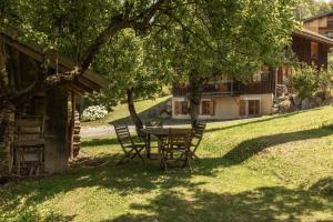a table and chairs under a tree in a yard at Petit Bois - by Care Concierge in Demi-Quartier