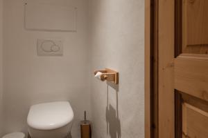 a bathroom with a toilet and a toilet paper dispenser at Petit Bois - by Care Concierge in Demi-Quartier