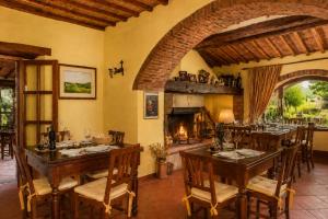 a dining room with a table and a fireplace at Borgo Livernano in Radda in Chianti