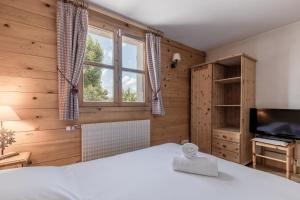 a bedroom with a bed and a tv and a window at Petit Bois - by Care Concierge in Demi-Quartier