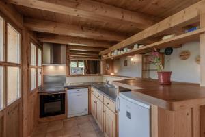 a large kitchen with wooden walls and wooden counters at Petit Bois - by Care Concierge in Demi-Quartier +9 photos