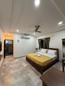 a bedroom with a large bed and a table at Nakshatra Boarding and Lodging in Mangalore International