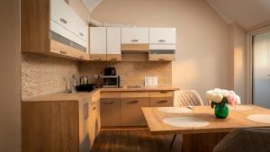 a kitchen with a table with a vase of flowers on it at Pearl Home in Békéscsaba
