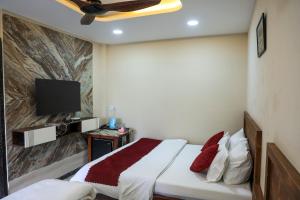 a bedroom with a bed and a flat screen tv at Hotel Omkara View Palace in Godarpura