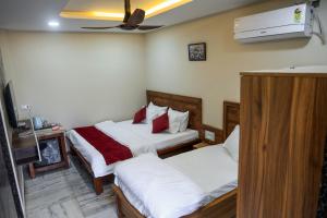 a hotel room with two beds and a tv at Hotel Omkara View Palace in Godarpura