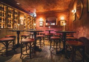 a bar with tables and stools in a room at The Goat in Boots in London