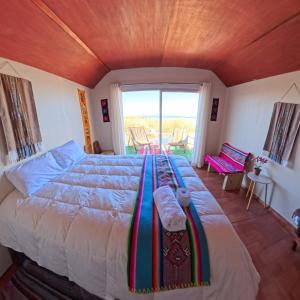 a bedroom with a large bed with a wooden ceiling at Islas Chimu in Puno