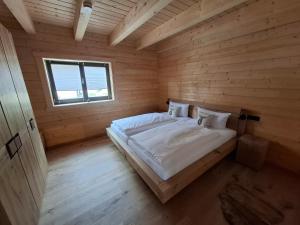a large bed in a wooden room with a window at Schwarzwald Wellness Chalet in Todtnau +41 photos