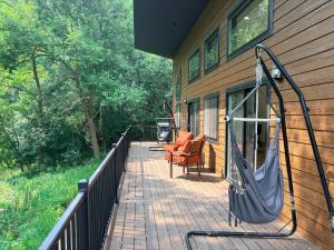 a porch with a swing on the side of a house at Driftless Destinations in McGregor