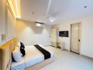 a bedroom with a bed and a television in it at Hotel Grand Elite- Ghaziabad in Ghaziabad